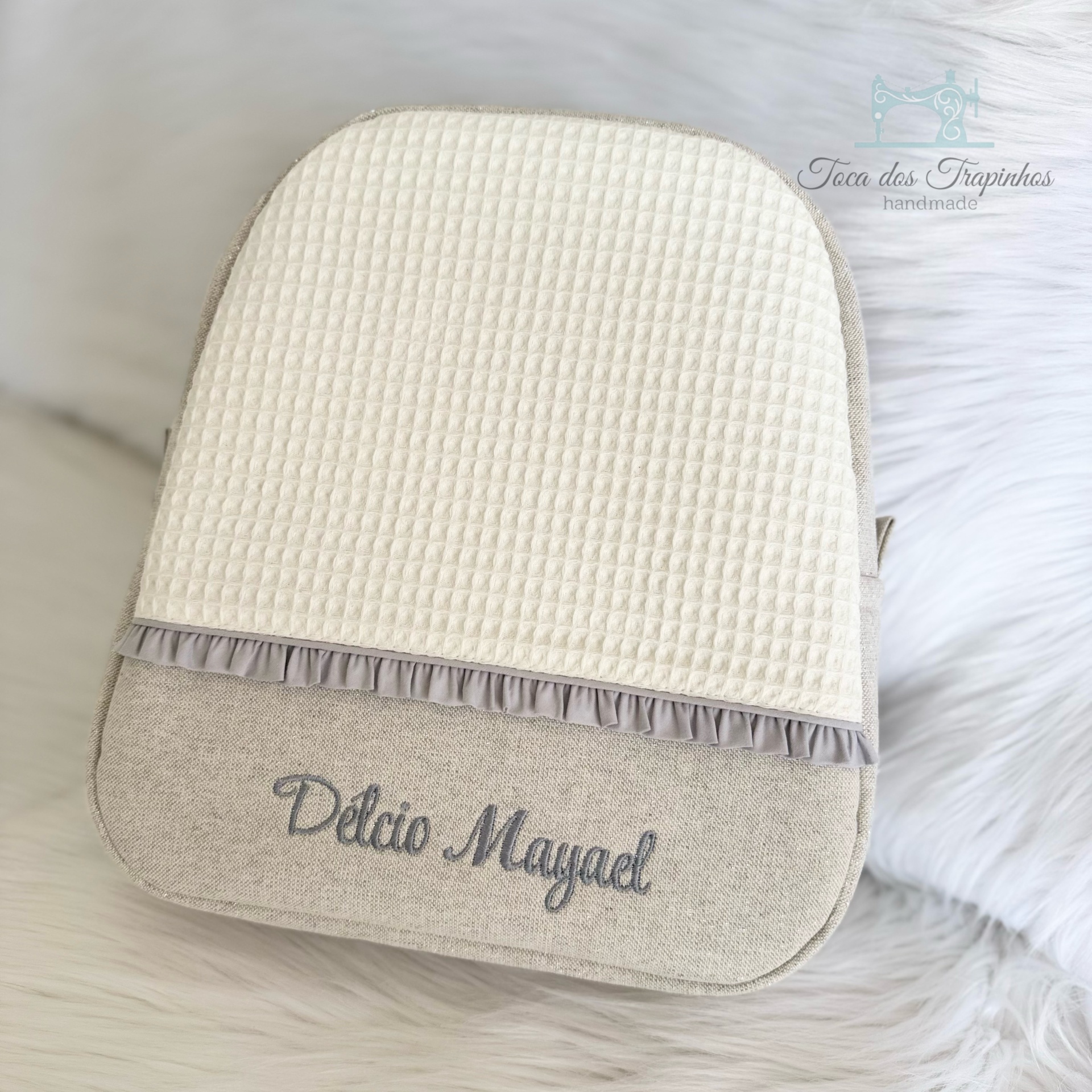Bolsa tecido bege com detalhe branco texturizado e bordado cinza com nome Déclio Mayral