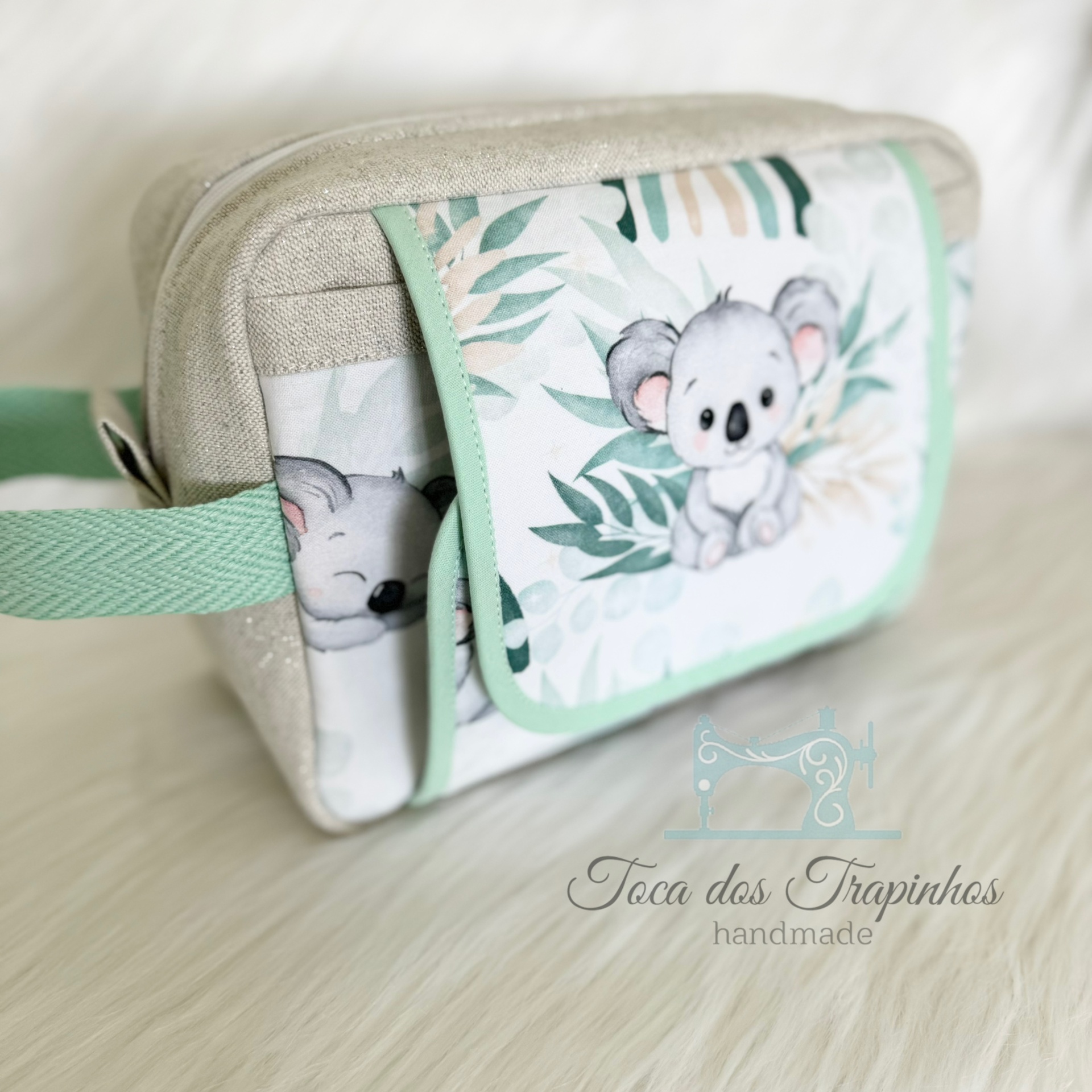 Necessaire em tecido com desenho de coala e folhas e texto handmade