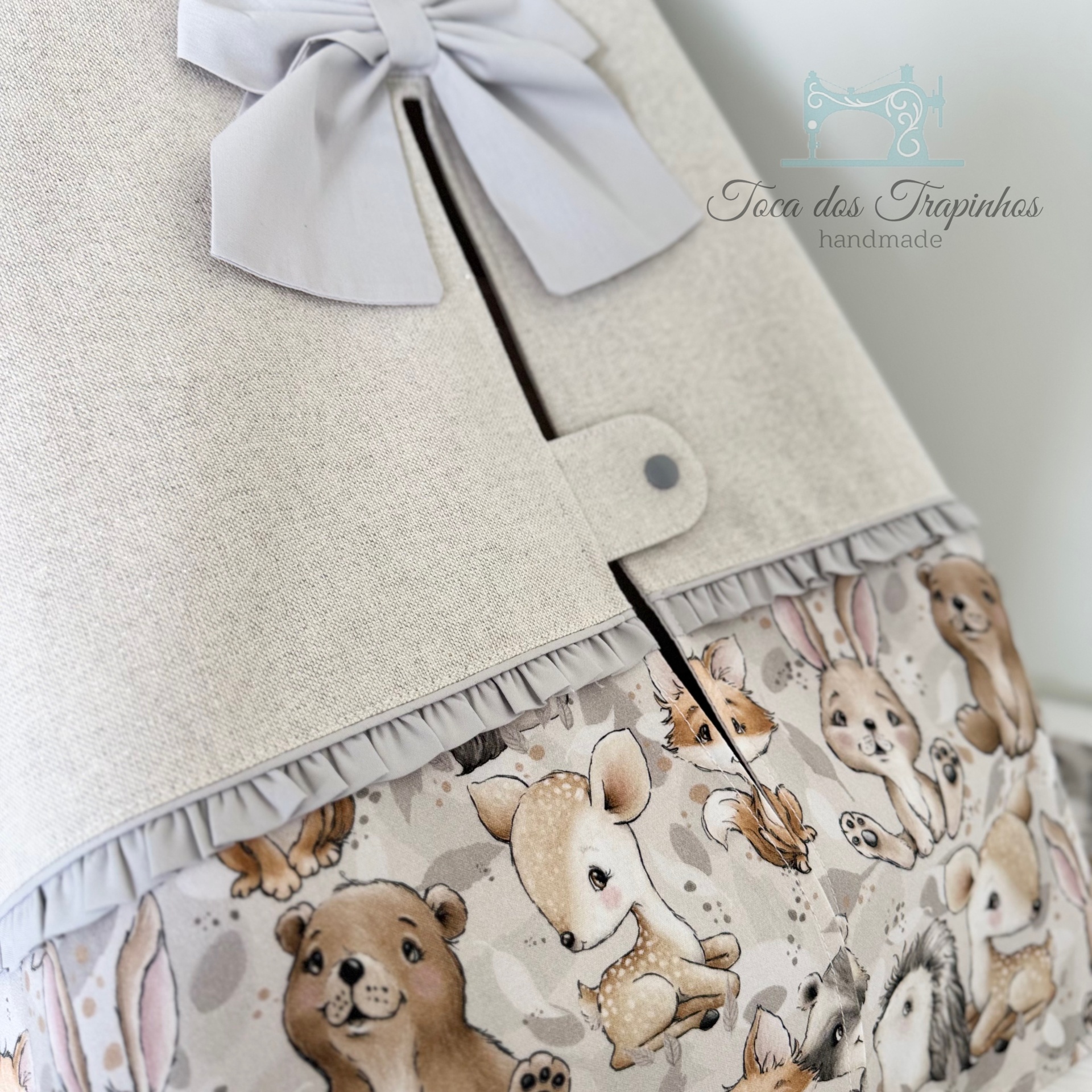Saco em tecido bege com padrão de animais e laço cinzento