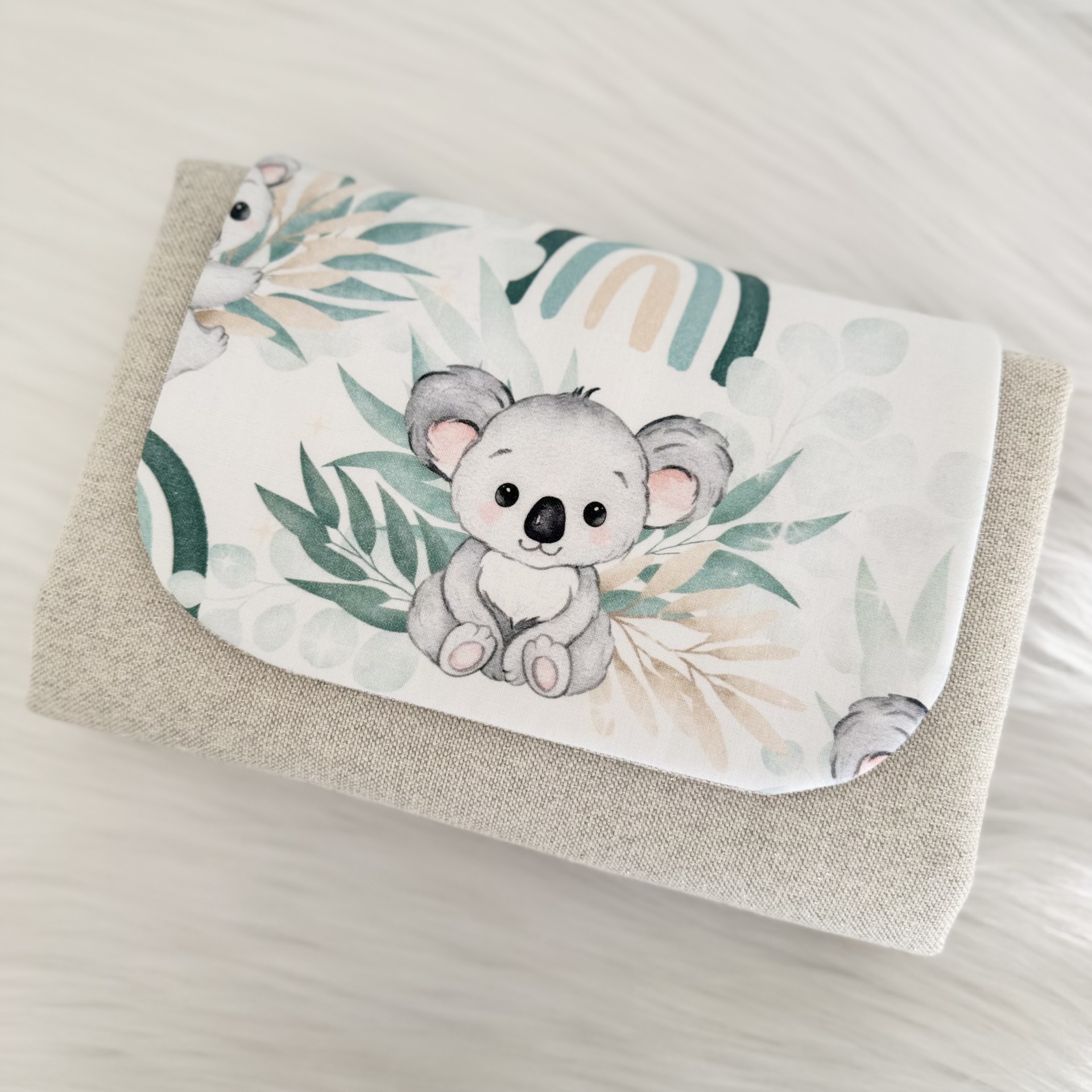 Carteira bege com aba branca com desenho de coala e folhas