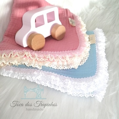 Três panos de boca coloridos com renda e brinquedo de madeira em forma de carro