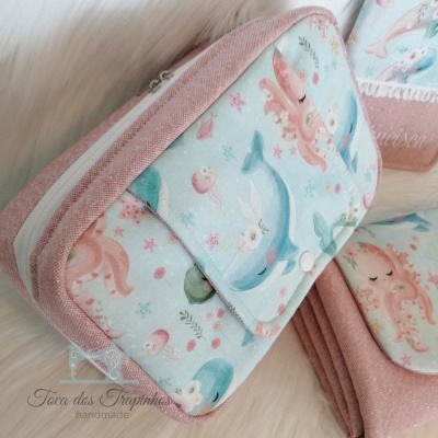 Carteira rosa com estampa de animais marinhos sobre superfície macia