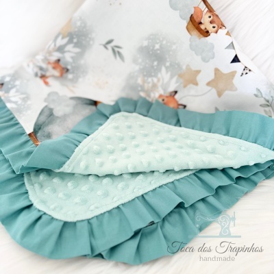 Manta de bebé azul claro com textura de bolinhas e estampa de animais e estrelas