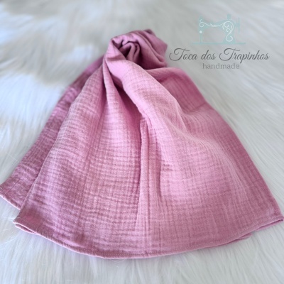 Lenço rosa com padrão quadriculado sobre tecido branco felpudo