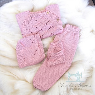 Conjunto de roupa de bebé cor-de-rosa em tricô com camisola, calças, gorro e luvas