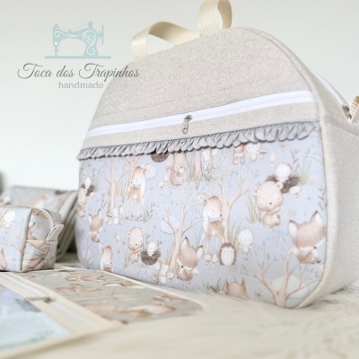 Bolsa tecido padrão animais floresta tons pastel com zíper branco e detalhe franzido