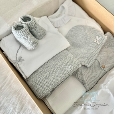 Conjunto de roupa de bebé cinza e branca em caixa