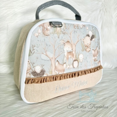 Bolsa infantil de tecido com padrão de animais da floresta em fundo azul claro e detalhes em castanho