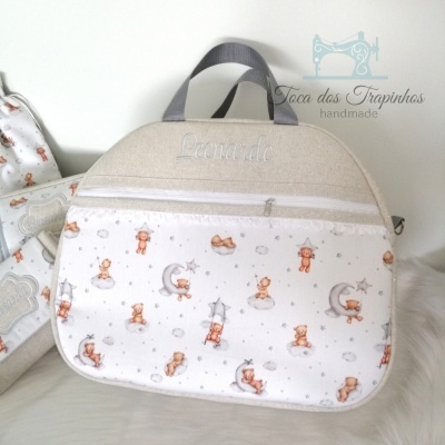 mala para bebé com ursa, luas e estrelas em tecido branco, alças cinza e detalhe em linho bege
