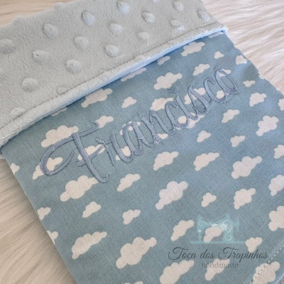 Manta azul com nuvens brancas e bordado com o nome Francisco