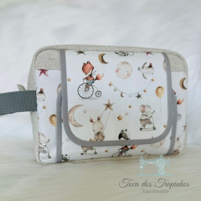 Bolsa multiusos com padrão de animais e estrelas em tecido branco e cinza.