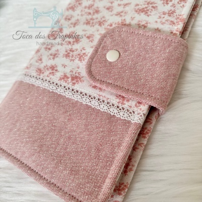 proteção para livro ou caderno em tecido rosa com padrão floral e fecho botão