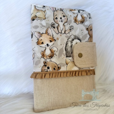 Capa de tecido para livro com padrão de animais e aba de fecho em tecido bege