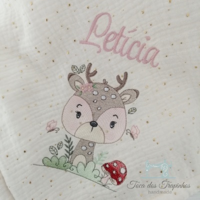Tecido branco com desenho bordado de veado, cogumelo, folhas, borboletas e texto Letícia