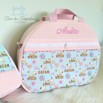 Bolsa infantil rosa com padrão azul claro com desenhos e palavras, nome Anita bordado