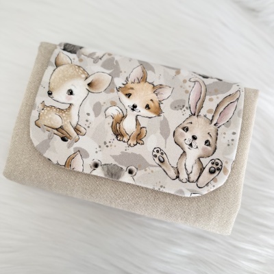 Bolsa em tecido bege com aba estampada com desenhos de animais baby