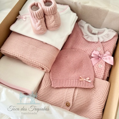 Conjunto de roupa de bebé rosa e branca com sapatinhos, body, mantas, camisola e touca em caixa