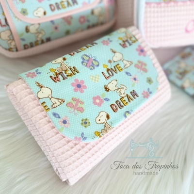 Carteira de tecido com padrão de personagens e palavras inspiradoras, detalhes em rosa e azul claro