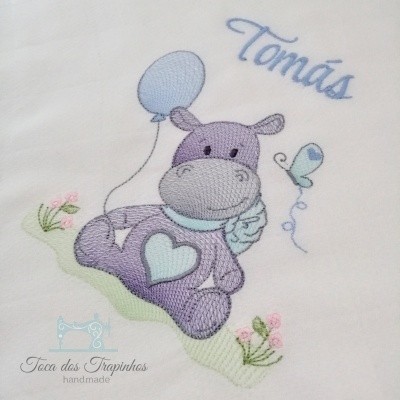 Bordado de hipopótamo com balão e borboleta, nome Tomás em tecido branco