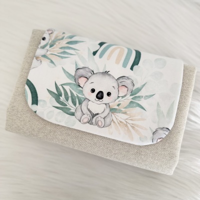 Carteira bege com aba branca com desenho de coala e folhas