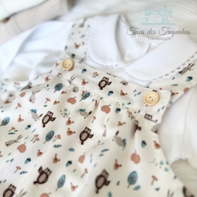 Roupa de bebé com camisa branca e jardineira estampada bege clara