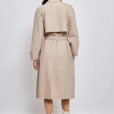 Trench coat bege feminino visto de trás com botas bege claras