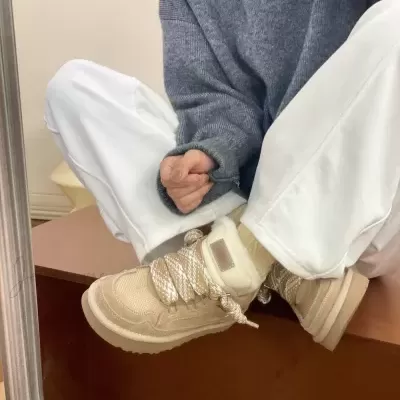 Tênis tipo bota bege com cadarços grossos e forro de pelo branco