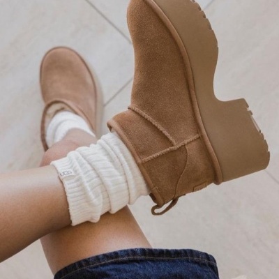 Botas castanhas de camurça com sola grossa castanha usadas com meias brancas e roupa azul escura