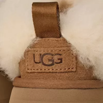 Detalhe de botim castanho UGG com lã branca e etiqueta
