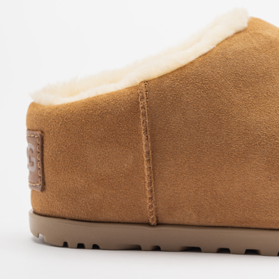 Pantufa castanha em camurça com interior felpudo branco e etiqueta UGG no calcanhar