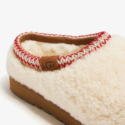 Pantufa felpuda creme com sola castanha e costura vermelha e bege, etiqueta UGG em pele castanha