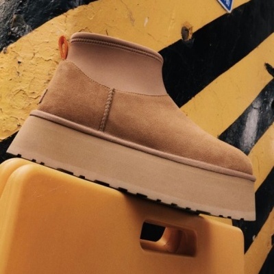 Bota bege de camurça com sola plataforma em fundo amarelo e preto