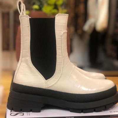 Botas Chelsea brancas com padrão crocodilo e sola preta.