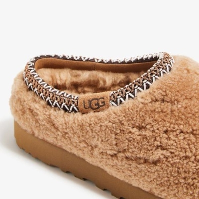 Pantufa UGG caramelo felpuda com detalhe em ponto cruz e etiqueta UGG