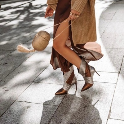 Botas femininas de salto alto castanho e bege prateado com vestido castanho e casaco de malha castanho claro na rua