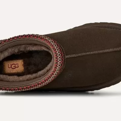 Bota castanha UGG com bordado vermelho e bege, interior forrado a pele e etiqueta UGG no interior