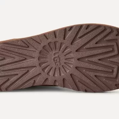 Sola de sapato castanha com padrão geométrico e texto UGG