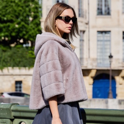 Casaco cinza claro de pêlo sintético com capuz e saia azul escura