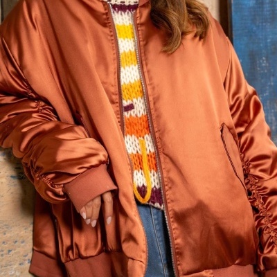 Casaco bomber acetinado laranja com fecho e elásticos nas mangas.