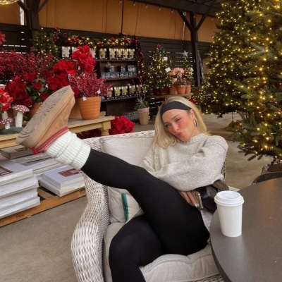 Pessoa sentada num sofá de vime branco, com decoração natalícia ao fundo