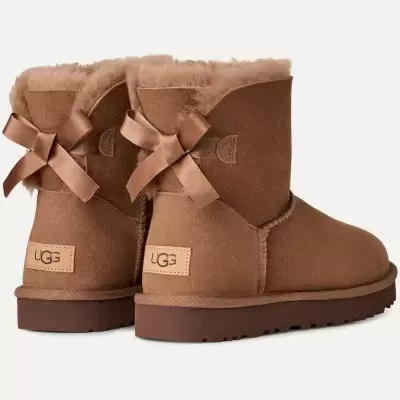 Botas UGG castanhas com laços atrás e pelo na borda.