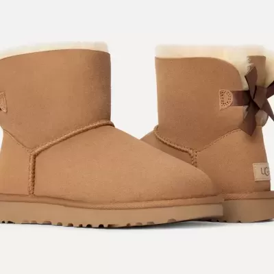 Bota UGG castanha clara com laço atrás e sola de borracha.