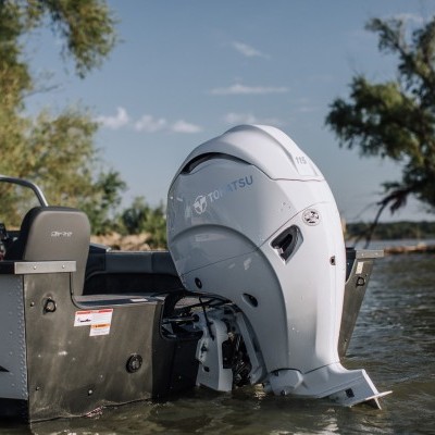 Motor de popa branco Tohatsu 3.5HP numa embarcação cinza em ambiente aquático