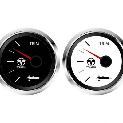 Dois medidores redondos com molduras prateadas, um de fundo preto e outro de fundo branco, com texto TRIM e logo TOHATSU.