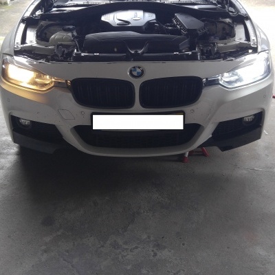 Frente de carro BMW branco com capot aberto e motor visível