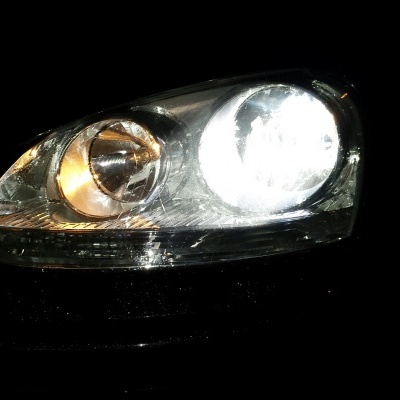 Farol de carro com lâmpadas ligadas em fundo preto