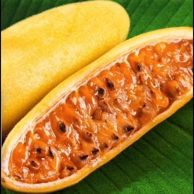 Fruta amarela aberta mostrando interior alaranjado com sementes sobre folha verde.