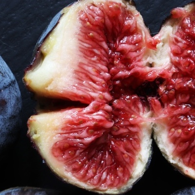Figos frescos com um cortado ao meio mostrando a polpa vermelha