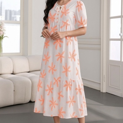 Vestido midi branco com flores alaranjadas e mangas curtas num ambiente interior moderno