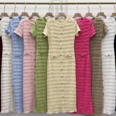 Nove vestidos de malha coloridos pendurados num varão